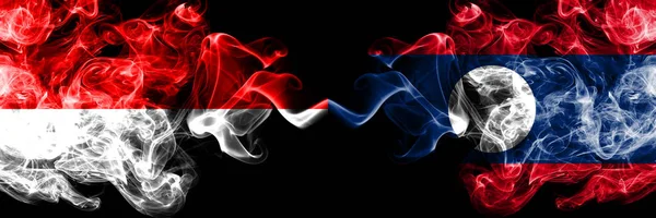 Indonesia vs Laos smoky mystic flags placed side by side. Thick colored silky smoke flags of Indonesia and Laos — Stock Photo, Image