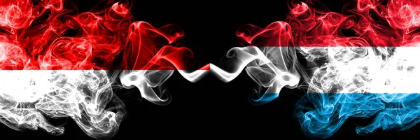印度尼西亚 vs 卢森堡 烟熏神秘旗帜并排放置。印度尼西亚和卢森堡的厚彩色丝质烟旗 — 图库照片