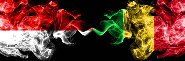 Indonezja vs Mali smoky Mystic flagi umieszczone obok siebie. Grube kolorowe, jedwabiste flagi dymu z Indonezji i Mali — Zdjęcie stockowe