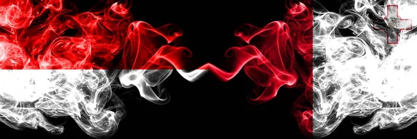 Indonésia vs Malta, bandeiras místicas fumegantes maltesas colocadas lado a lado. Bandeiras de fumaça sedosa de cor grossa da Indonésia e Malta, maltês — Fotografia de Stock