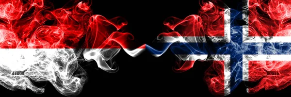 Indonésia vs Noruega, bandeiras místicas fumegantes norueguesas colocadas lado a lado. Bandeiras de fumaça sedosa de cor grossa da Indonésia e Noruega, norueguês — Fotografia de Stock