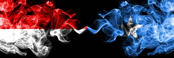 Индонезия против Сомали, сомалийские дымящиеся мистические флаги, помещенные бок о бок. Толстые шёлковые дымовые флаги Индонезии и Сомали — стоковое фото