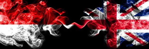Индонезия против Великобритании, британские дымовые мистические флаги, расставленные бок о бок. Толстые шёлковые дымовые флаги Индонезии и Великобритании — стоковое фото