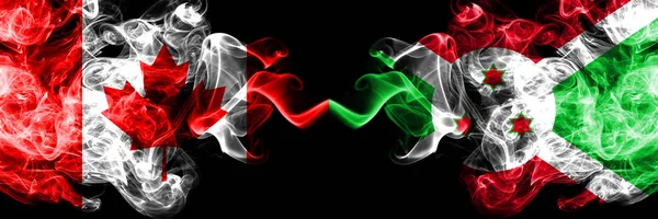 Canadá vs Burundi, bandeiras místicas esfumaçadas do Burundi colocadas lado a lado. Bandeiras de fumo sedoso de cor grossa do Canadá e Burundi, Burundi . — Fotografia de Stock