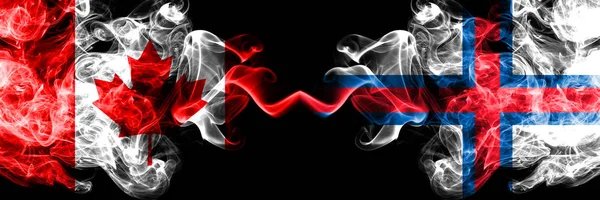 Kanada vs Färöer Inseln rauchige mystische Flaggen nebeneinander aufgestellt. dicke, seidige Rauchfahnen der kanadischen und färöischen Inseln. — Stockfoto