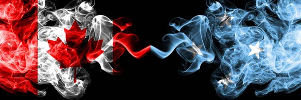 Canadá vs Micronésia, bandeiras místicas micronésias fumegantes colocadas lado a lado. Bandeiras de fumaça sedosa coloridas grossas de canadense e Micronésia, Micronésia . — Fotografia de Stock