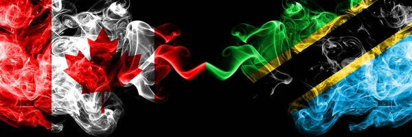 Canadá vs Tanzânia, bandeiras místicas fumegantes da Tanzânia colocadas lado a lado. Bandeiras de fumaça sedosa coloridas grossas do canadense e da Tanzânia, Tanzânia . — Fotografia de Stock