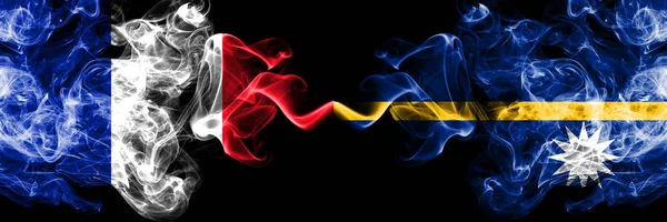 Francia vs Nauru banderas místicas ahumadas colocadas lado a lado. Bandera de humo abstracta sedosa de color grueso de francés y Nauru —  Fotos de Stock