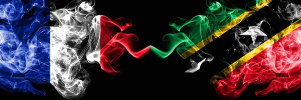 Francja vs Saint Kitts i Nevis smoky mistyczne flagi umieszczone obok siebie. Gruby, jedwabisty, abstrakcyjny baner dymu francuskiego i Saint Kitts i Nevis — Zdjęcie stockowe