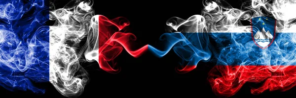 Frankrike vs Slovenien, slovenska rökiga mystiska flaggor placerade sida vid sida. Tjock färgad silkeslen abstrakt rök banner av franska och Slovenien, slovenska — Stockfoto