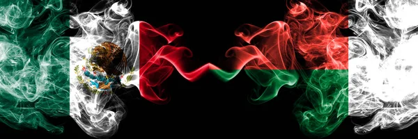 Meksika vs Madagaskar, Madagaskar dumanlı mistik bayraklar yan yana yerleştirilir. Kalın renkli ipeksi soyut Meksika ve Madagaskar, Madagaskar afiş dumanlar