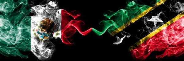 Meksika vs Saint Kitts ve Nevis dumanlı mistik bayraklar yan yana yerleştirilir. Kalın renkli ipeksi soyut Meksika ve Saint Kitts ve Nevis ve afiş dumanlar