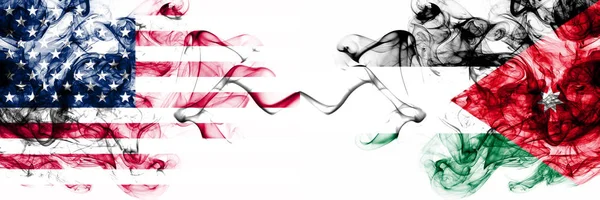 Estados Unidos vs Jordania, banderas místicas humeantes jordanas colocadas una al lado de la otra. Bandera de humo abstracto sedoso de color grueso de América y Jordania, Jordania — Foto de Stock