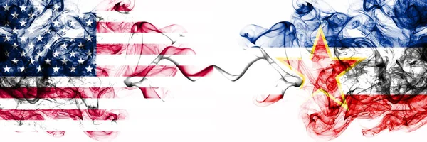 Estados Unidos vs Yugoslavia banderas místicas ahumadas colocadas una al lado de la otra. Bandera de humo abstracto sedoso de color grueso de América y Yugoslavia —  Fotos de Stock
