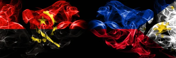 Angola, angolanska, Filippinerna, filippinska rökiga mystiska flaggor placerade sida vid sida. Tjocka färgade silkeslena röker flagga koncept — Stockfoto