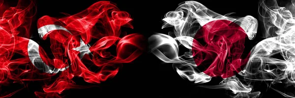 Turkiet, turkiska, Japan, japanska rökiga mystiska flaggor placerade sida vid sida. Tjocka färgade silkeslena röker flagga koncept — Stockfoto