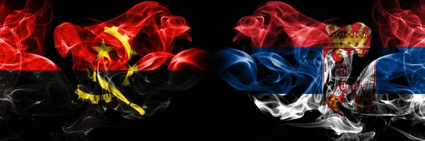 Angola, Angolan, Serbia, Serbian smoky mystical flags placed side by side. Thick colored silky smokes flag concept — Stock Photo, Image