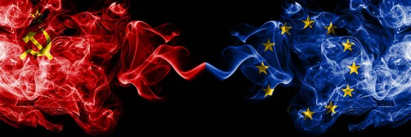 Kommunistiska vs Europeiska unionen, EU abstrakt rökiga mystiska flaggor placerade sida vid sida. Tjocka färgade silkeslen rök flaggor av kommunismen och Europeiska unionen, EU — Stockfoto
