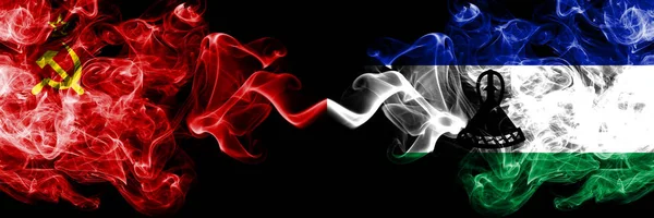 Drapeaux mystiques fumés abstraits communistes vs Lesotho placés côte à côte. Drapeaux de fumée soyeux de couleur épaisse du communisme et du Lesotho — Photo