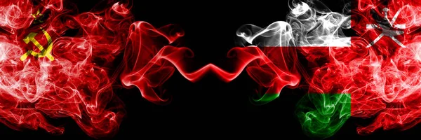 Communist vs Oman, Omani abstracte rokerige mystieke vlaggen naast elkaar geplaatst. Dikke gekleurde zijdeachtige rook vlaggen van het communisme en Oman, Omani — Stockfoto