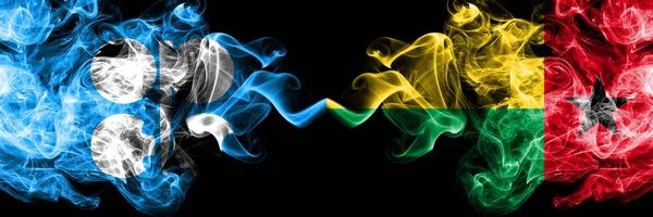 Opec vs Guinea Bissau abstract smoky mystic прапори розміщені пліч-о-пліч. Товсті кольорові прапори з шовкового диму в Опеці й Гвінеї Бісау — стокове фото