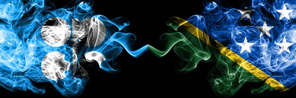 Опек проти Соломонових островів абстрактний димний містичний прапор розміщений пліч-о-пліч. Товсті жовті прапори диму в Опеку і Соломонових островах. — стокове фото