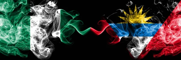 Nigeria vs Antigua and Barbuda abstract smoky mystic flags placed side by side. Thick colored silky smoke flags of Nigerian and Antigua and Barbuda