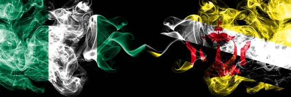 Нігерія проти Брунею, брунейські абстрактні димові містичні прапори розміщені пліч-о-пліч. Товстий колір шовковий дим прапори Нігерії і Брунею, Бруней — стокове фото