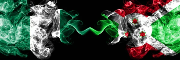 Nigeria vs Burundi, Burundese abstracte rokerige mystieke vlaggen naast elkaar geplaatst. Dikke gekleurde zijdeachtige rook vlaggen van Nigeriaanse en Burundi, Burundese — Stockfoto