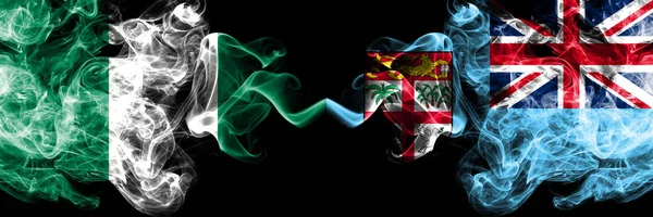 Nigéria vs Fiji bandeiras místicas fumegantes abstratas colocadas lado a lado. Bandeiras de fumaça sedosa coloridas grossas de nigeriano e Fiji — Fotografia de Stock