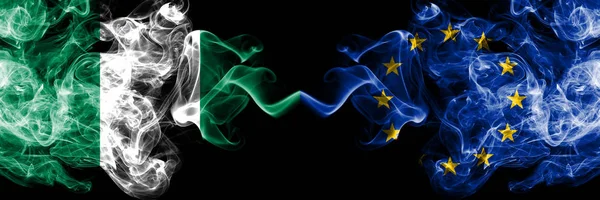 Nigeria kontra Europeiska unionen, Europa abstrakta rökiga mystiska flaggor placerade sida vid sida. Tjock färgad silkeslen rök flaggor av nigerianska och Europeiska unionen, Europa — Stockfoto