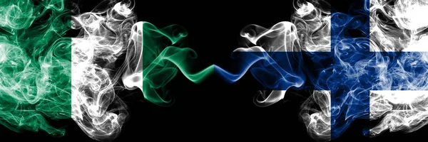 Nigeria vs Finlandia, banderas místicas ahumadas abstractas FInnish colocadas una al lado de la otra. Banderas de humo sedoso de color grueso de Nigeria y Finlandia, FInnish — Foto de Stock