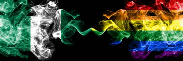 Нігерія проти гей-гордості абстрактні димові містичні прапори розміщені пліч-о-пліч. Товсті, шовковисті прапори диму Нігерії та Ґей гордості — стокове фото
