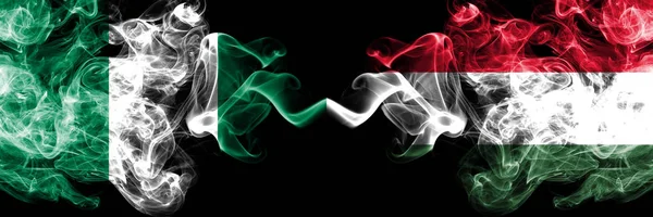 Nigeria vs ungary, ungarische abstrakte rauchige mystische Flaggen nebeneinander platziert. dicke farbige seidige Rauchfahnen nigerianischer und ungarischer, ungarischer — Stockfoto