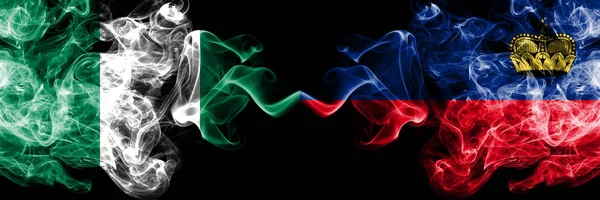 Nigérie vs Lichtenštejnsko, Thajci abstraktní kouřové mystické vlajky umístěny vedle sebe. Silné barevné hedvábné kouřové vlajky Nigérie a Lichtenštejnska, Thajsko — Stock fotografie
