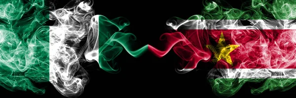 Nigeria vs Suriname, Surinamese abstract smoky mystic flags placed side by side. Thick colored silky smoke flags of Nigerian and Suriname, Surinamese — Stock Photo, Image