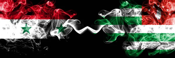 Сирія проти Абхазії, абхазькі димові прапори розміщені пліч-о-пліч. Товсті кольорові шовкові прапори диму Сирійської та Абхазії, абхазька — стокове фото