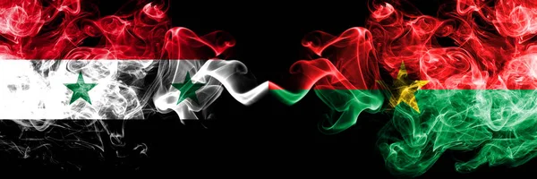 Сирія проти Буркіна-Фасо дим прапори розміщені поруч. Товста кольорові шовковистою дим прапори Сирійський і Буркіна-Фасо — стокове фото