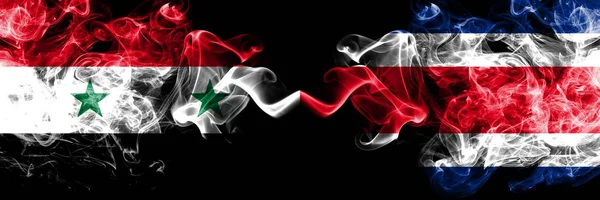 Syrien vs Costa Rica rök flaggor placeras sida vid sida. Tjock färgad silkeslen rök flaggor av syriska och Costa Rica — Stockfoto