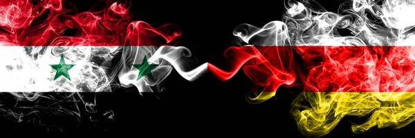 Syrië vs Zuid-Ossetië roken vlaggen naast elkaar geplaatst. Dikke gekleurde zijdeachtige rook vlaggen van Syrische en Zuid-Ossetië — Stockfoto