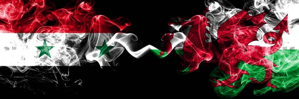Syria vs wales, walisische Rauchfahnen nebeneinander platziert. dicke, seidige Rauchfahnen aus Syrien und Walen, walisisch — Stockfoto