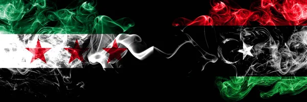 Syrische Arabische Republiek vs Libië, Libische rookvlaggen naast elkaar geplaatst. Dikke gekleurde zijdeachtige rook vlaggen van Syrië oppositie en Libië, Libisch — Stockfoto