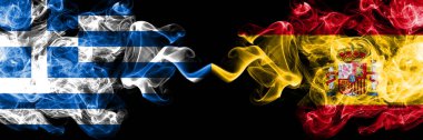 Yunanistan İspanya 'ya karşı, yan yana dikilmiş İspanyol dumanlı mistik bayrakları. Kalın renkli ipeksi soyut duman bayrakları.