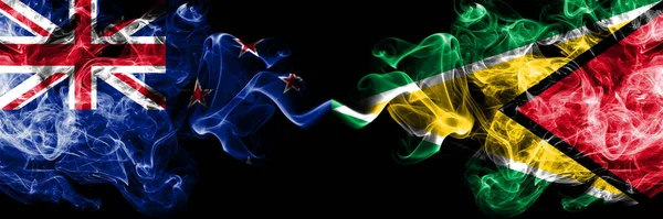 Yeni Zelanda, Guyana 'ya karşı Guyanese dumanlı mistik bayrakları yan yana yerleştirildi. Kalın renkli ipeksi soyut duman bayrakları