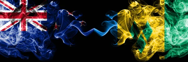 Yeni Zelanda, Saint Vincent ve Grenadines 'e karşı yan yana yerleştirilmiş dumanlı mistik bayraklar. Kalın renkli ipeksi soyut duman bayrakları