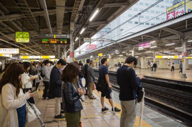 İnsanlar Tokyo Jr tren bekleyen platformunda