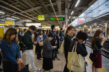 İnsanlar Tokyo Jr tren bekleyen platformunda