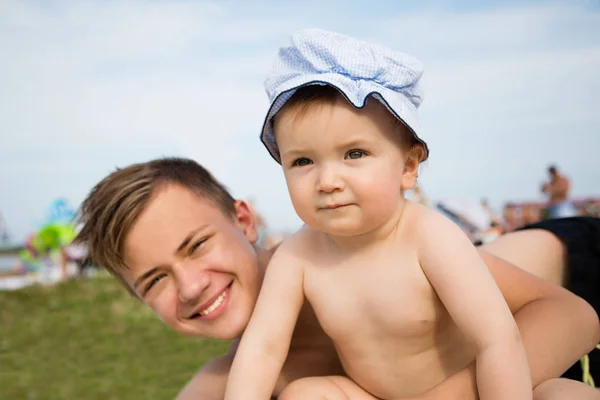 Eldest and youngest brother are relaxing on the beach — Stock Photo, Image