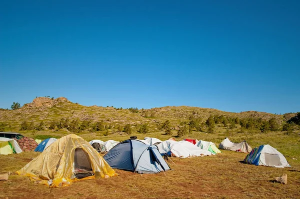 Campamento turístico en las tierras altas. Las tiendas están dispersas por los lados. . —  Fotos de Stock