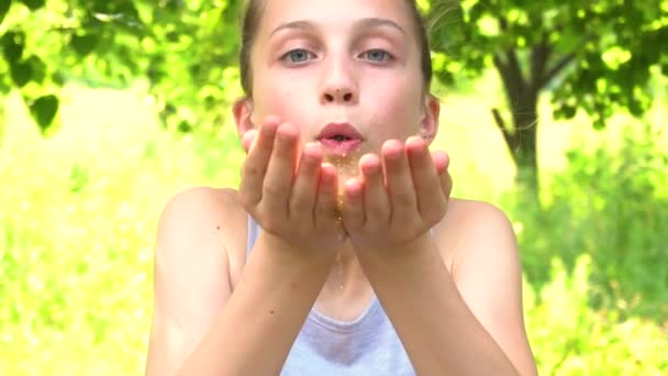 Игривая девушка, дующая на руки блестками — стоковое видео